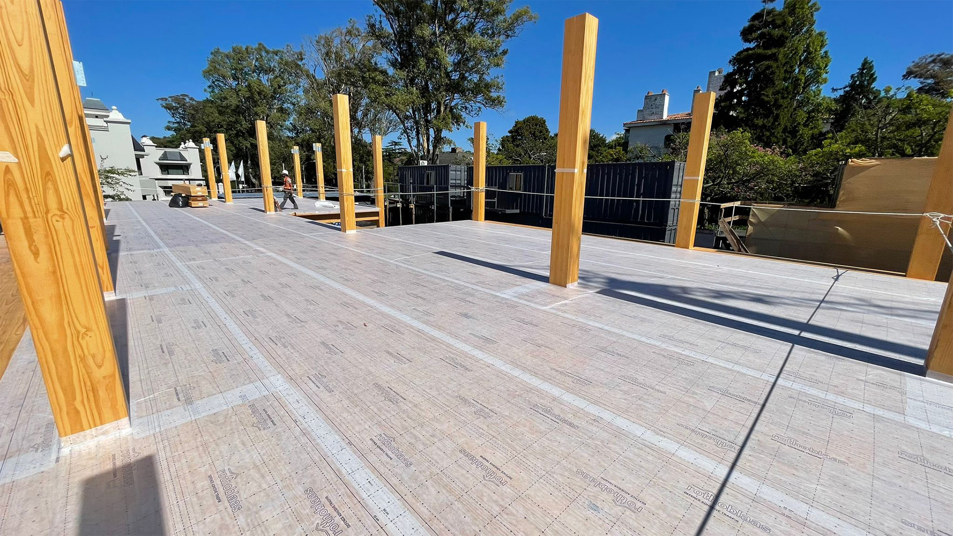 Mass timber construction site with self-adhesive breathable membrane applied on CLT floor for timber protection on site and moisture control. 