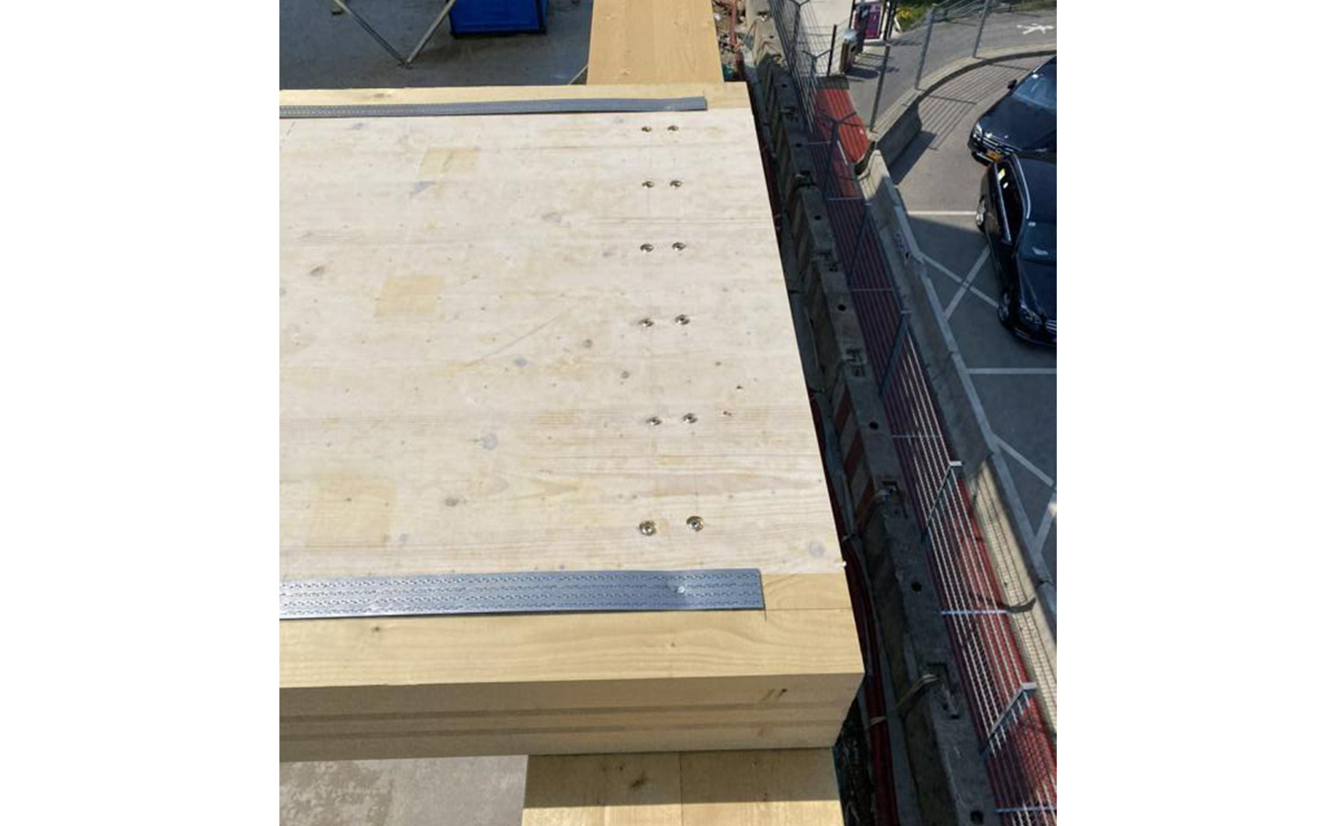 Timber floor slab with protective membrane installed on mass timber structure during construction