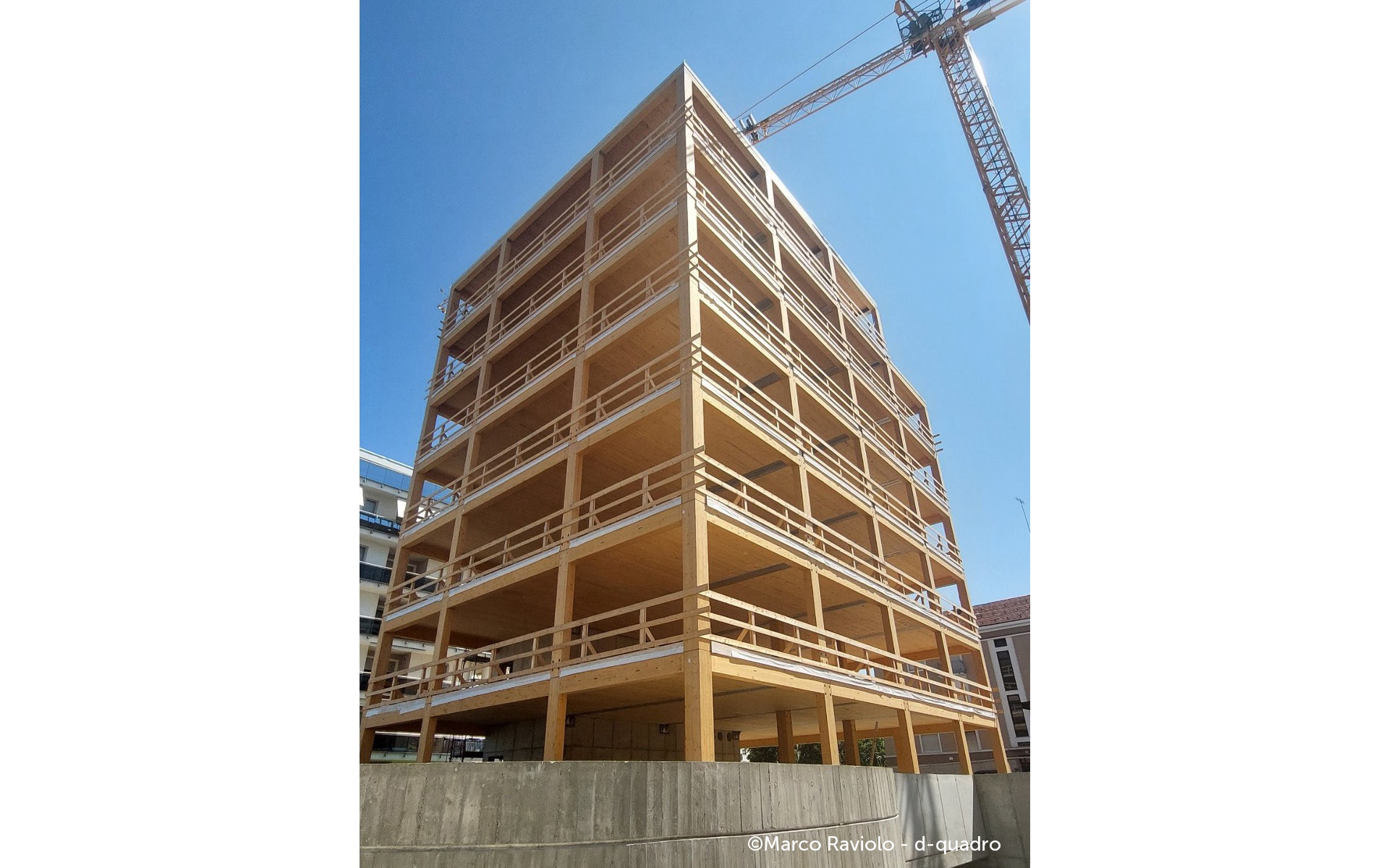 Timber construction site with temporary safety guardrails for prefabricated facade installation and off-site building retrofit